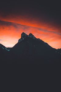 Scenic view of silhouette mountains against orange sky