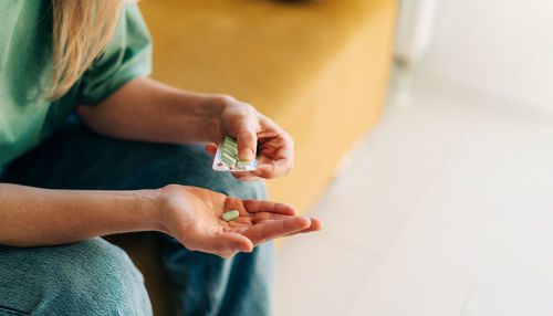 Close-up of a woman holding pills. copy space