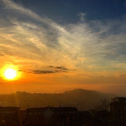 Scenic view of silhouette landscape against orange sky