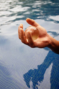 High angle view of person hand on swimming pool
