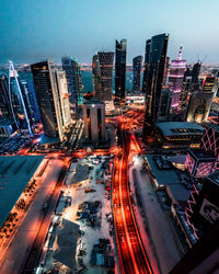 High angle view of illuminated street amidst buildings in city