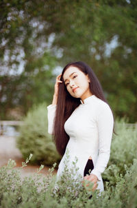 Beautiful woman standing by flower petals on land