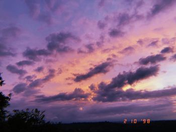 Low angle view of silhouette trees against dramatic sky