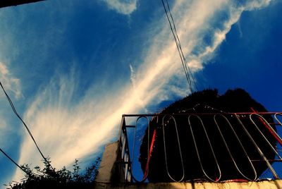 Low angle view of power lines against blue sky