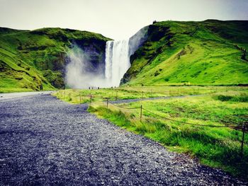 Scenic view of waterfall against sky