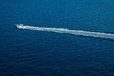 High angle view of boat sailing in blue sea on sunny day