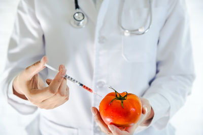 Health and medicine background, doctor is sampling skin care from tomato, research  