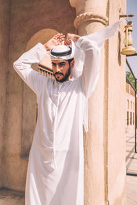 Portrait of arab man wearing dishdash kandura standing in historical disctrict