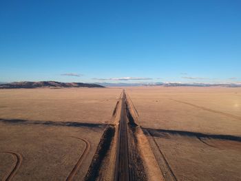 Scenic view of desert against clear blue sky