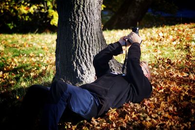 Low section of man sitting on field at park