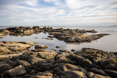 Rocks on beach against sky