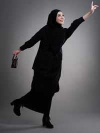 Low angle view of young woman standing against white background