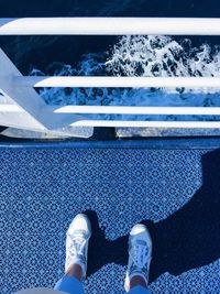Low section of person standing by swimming pool