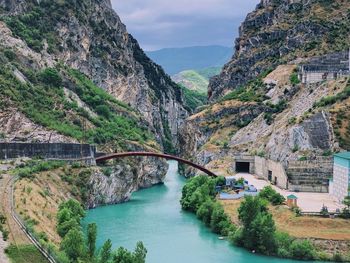 Arch bridge over river amidst mountains