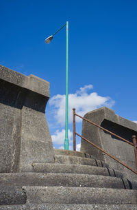 Concrete steps on a sea wall with a lamppost
