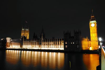 Big ben by thames river at night