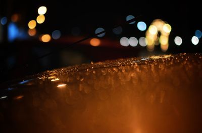 Defocused image of illuminated lights on wet street during rainy season