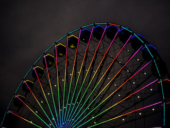 Low angle view of illuminated ferris wheel against sky at night