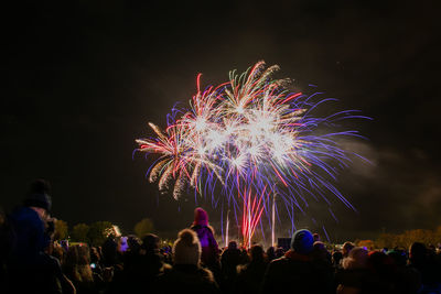 People watching firework display at night