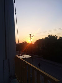 Silhouette electricity pylon against sky during sunset