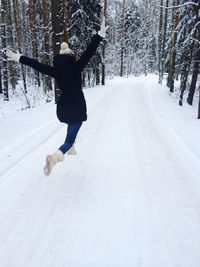 Playful woman on snow covered field