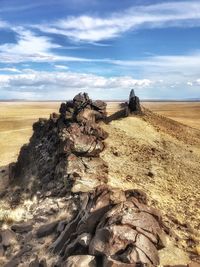 Scenic view of rocks on field against sky