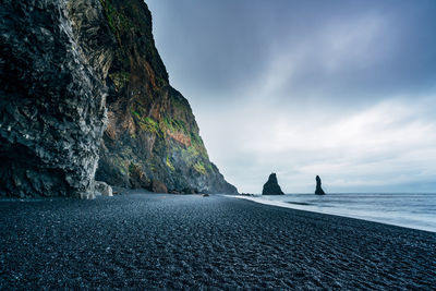 Scenic view of cliff face and rock formations on coastline