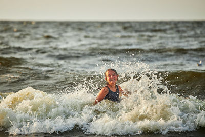 Rear view of man surfing in sea