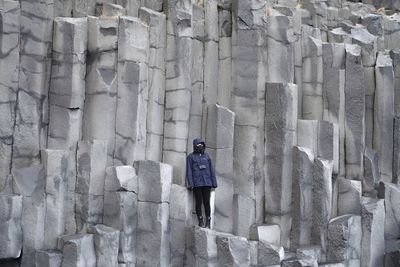 Rear view of woman standing against wall