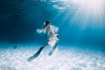 Rear view of woman swimming in sea