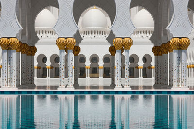 Columns of grand mosque reflecting on pool