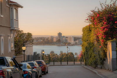 Street amidst buildings against sky during sunset