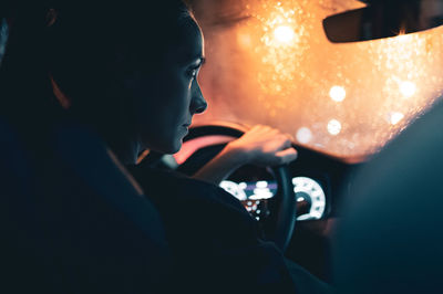 Rear view of woman watching map while driving car