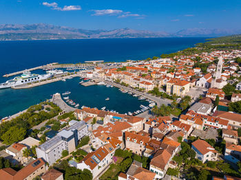 High angle view of townscape by sea against sky