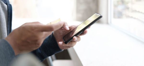 Midsection of man using mobile phone