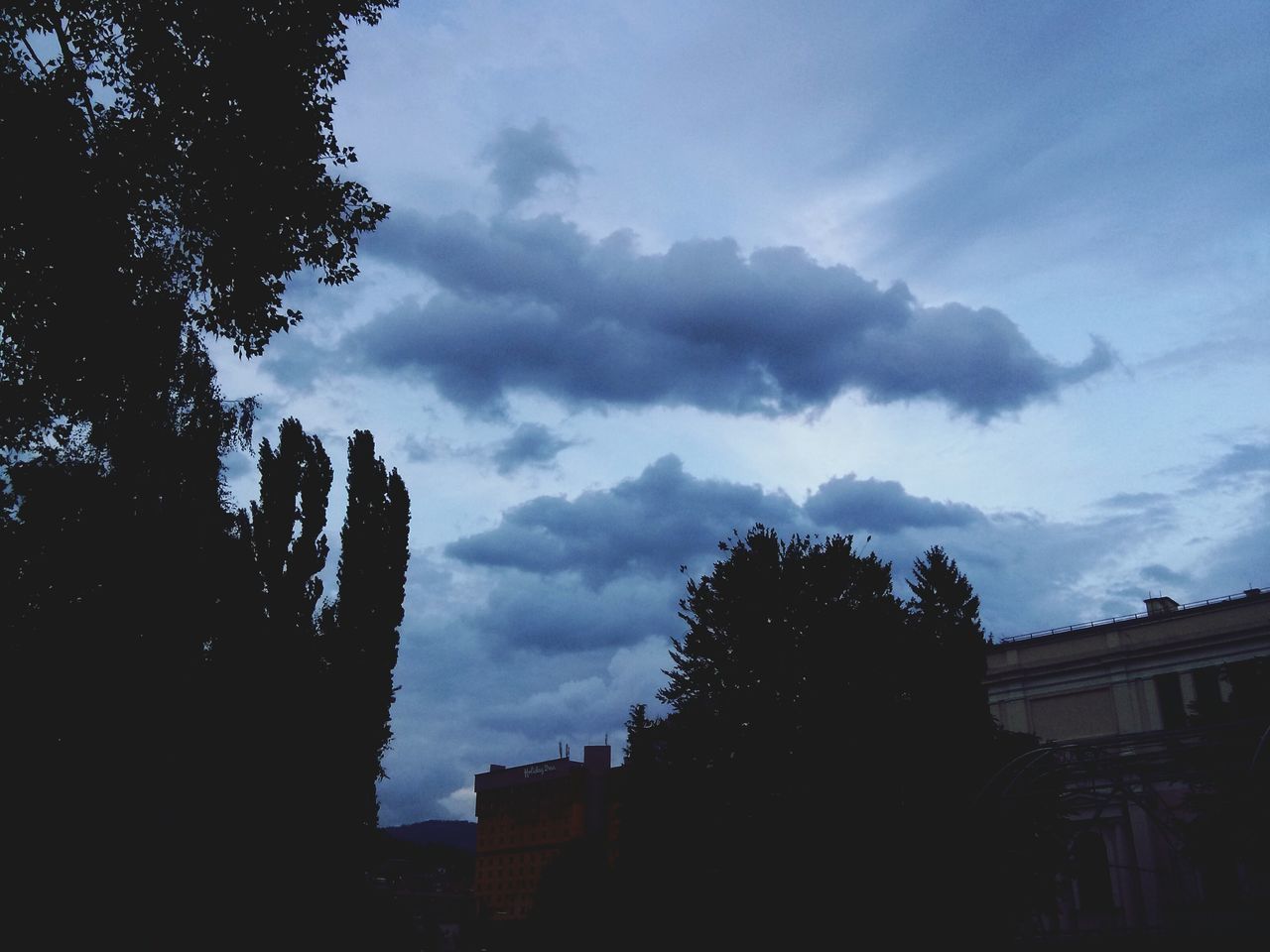 sky, building exterior, tree, built structure, architecture, cloud - sky, silhouette, low angle view, cloudy, cloud, house, dusk, weather, residential structure, nature, outdoors, residential building, no people, building, overcast