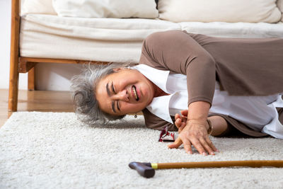 Portrait of a smiling woman lying on bed at home