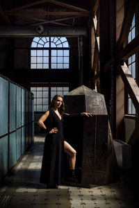 Full length portrait of woman standing in building