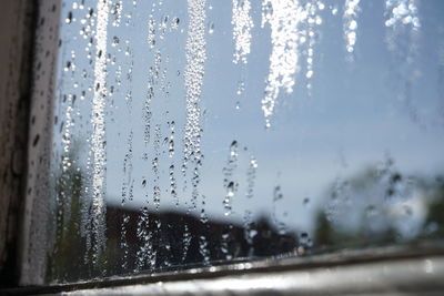 Close-up of wet glass window in rainy season