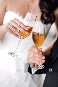 Cropped image of newlywed couple holding champagne in wedding ceremony