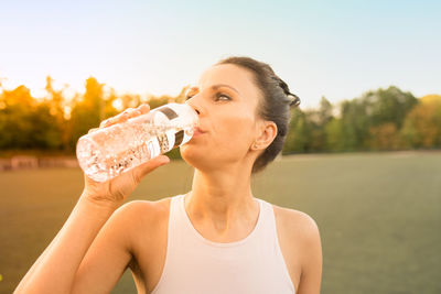 Close-up of woman drinking water outdoors