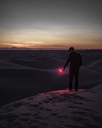 Man standing in desert with flaming torch