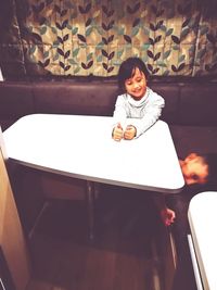 Portrait of smiling girl sitting on table