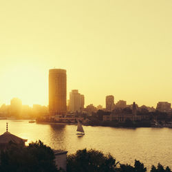 River in city against clear sky during sunset