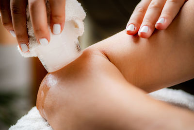 Ice massage for painful elbow. hands of a therapist placing ice directly onto a painful elbow 