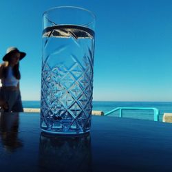 Reflection of glass of water in swimming pool