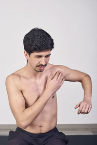 Young man looking away against white background