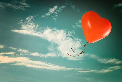 Low angle view of balloons flying against sky