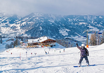 People snowboarding on snowcapped mountain