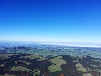 Aerial view of agricultural field against blue sky